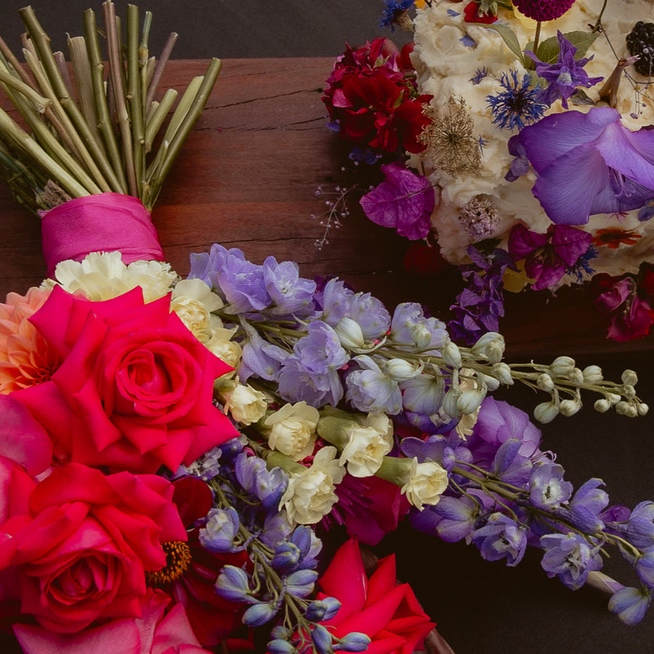 Decorative cake with flowers and grapes on a wooden board
